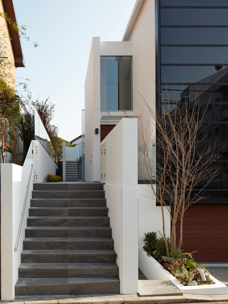 Design ideas for a large and brown modern glass house exterior in Tokyo with three floors.