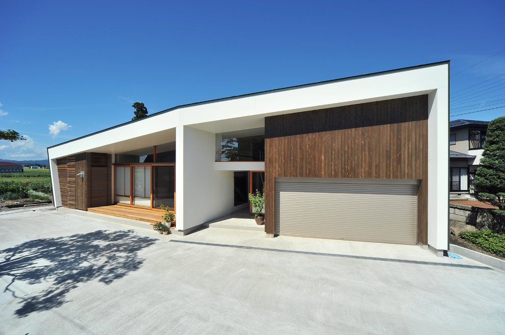 Cette image montre une façade de maison blanche design avec un toit à deux pans.