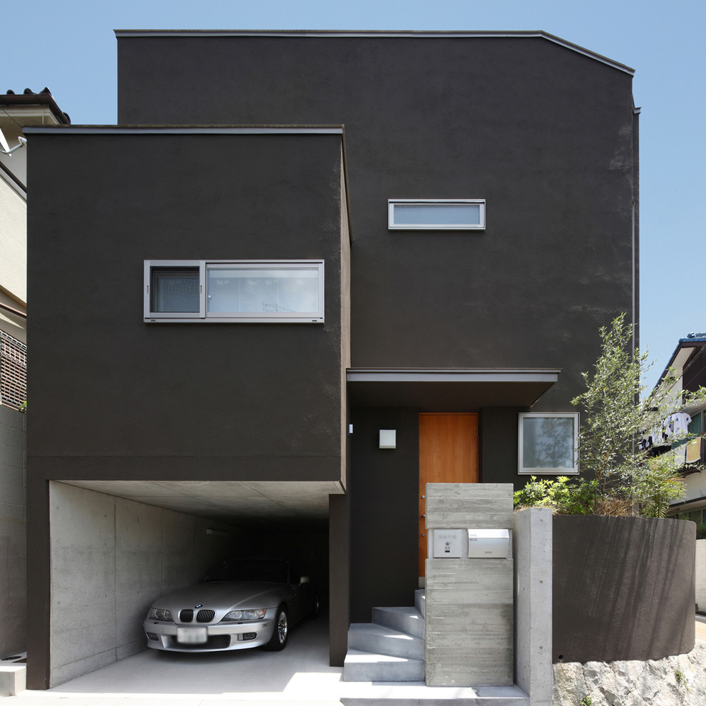 Aménagement d'une façade de maison noire asiatique de taille moyenne et à niveaux décalés avec un toit en métal.