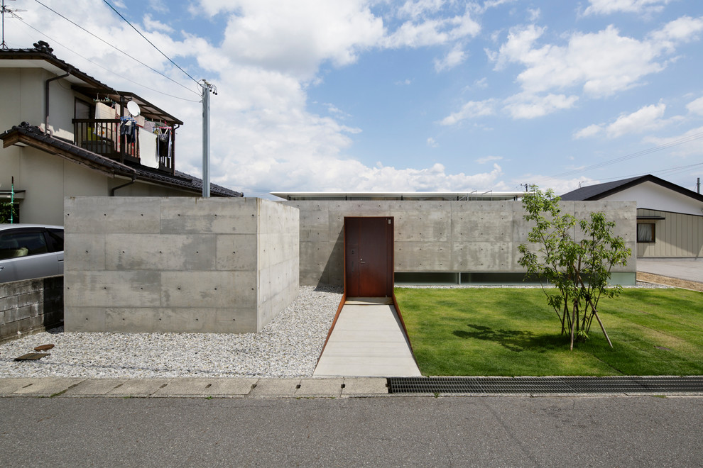 На фото: одноэтажный частный загородный дом среднего размера в стиле модернизм с облицовкой из бетона и плоской крышей