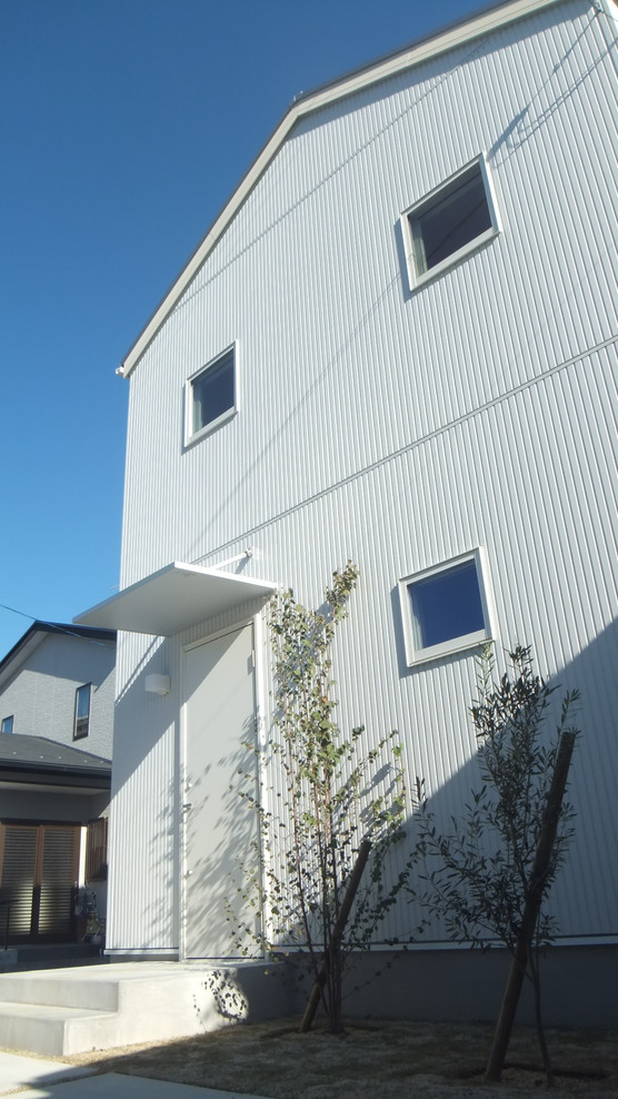 Свежая идея для дизайна: двухэтажный, белый частный загородный дом среднего размера в скандинавском стиле с комбинированной облицовкой, двускатной крышей и крышей из смешанных материалов - отличное фото интерьера