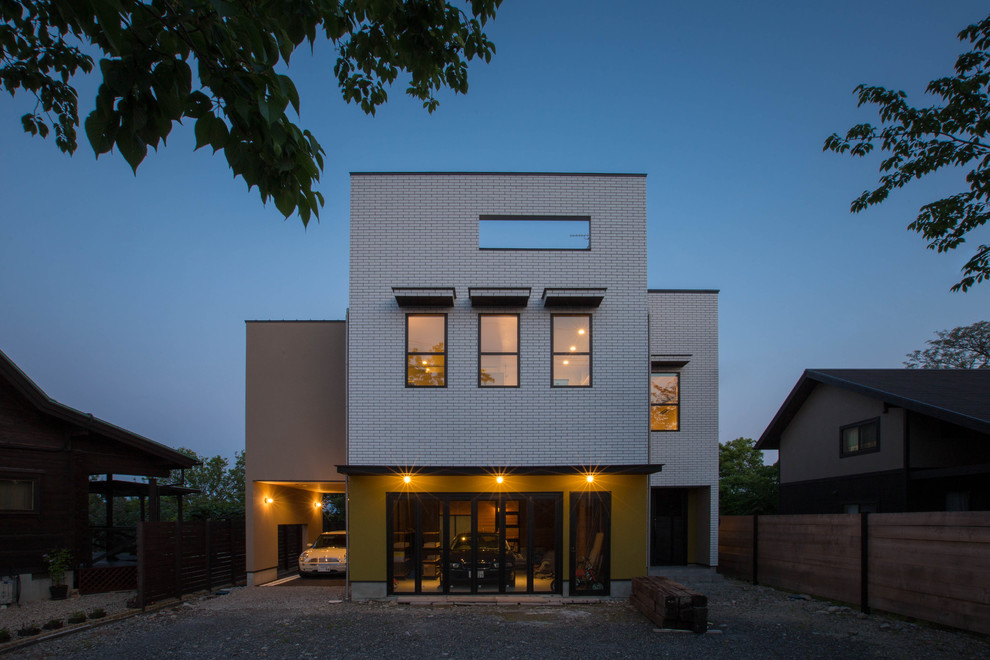 Стильный дизайн: трехэтажный, коричневый частный загородный дом с облицовкой из камня, односкатной крышей и металлической крышей - последний тренд