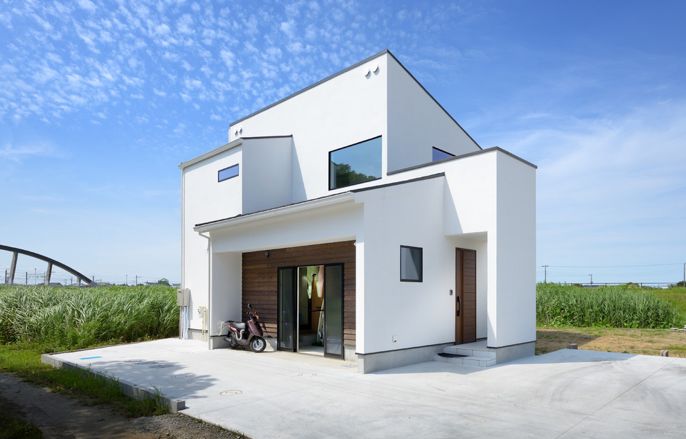 Aménagement d'une façade de maison blanche moderne de taille moyenne et à un étage.