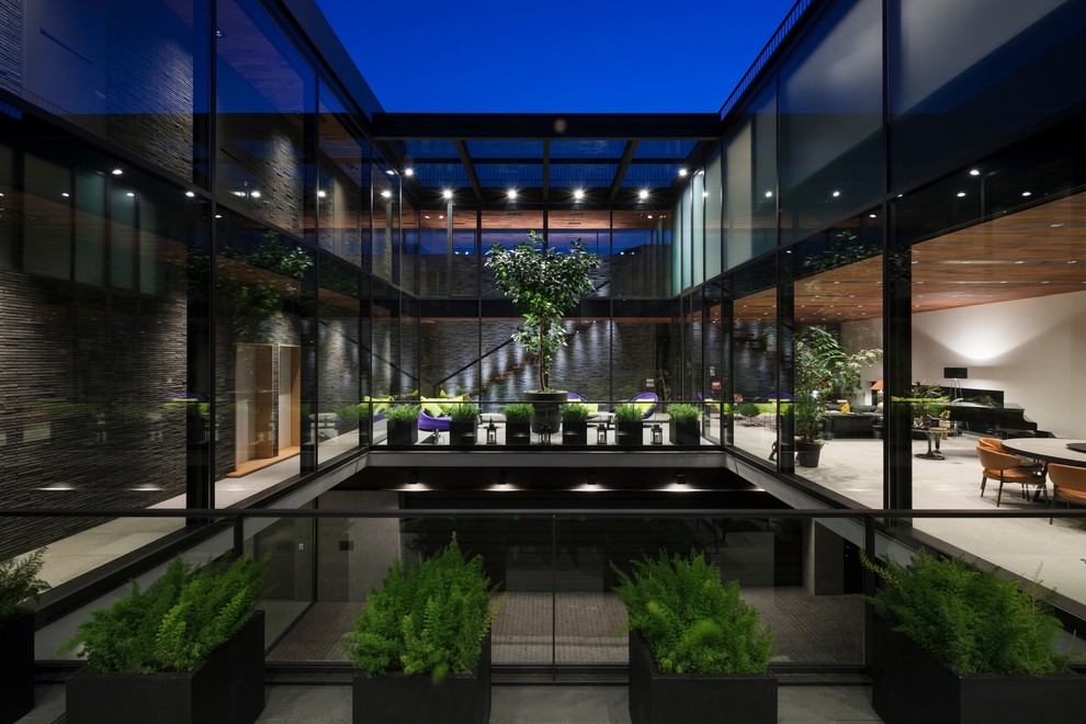 Стильный дизайн: двухэтажный, стеклянный, коричневый дом в современном стиле с плоской крышей - последний тренд