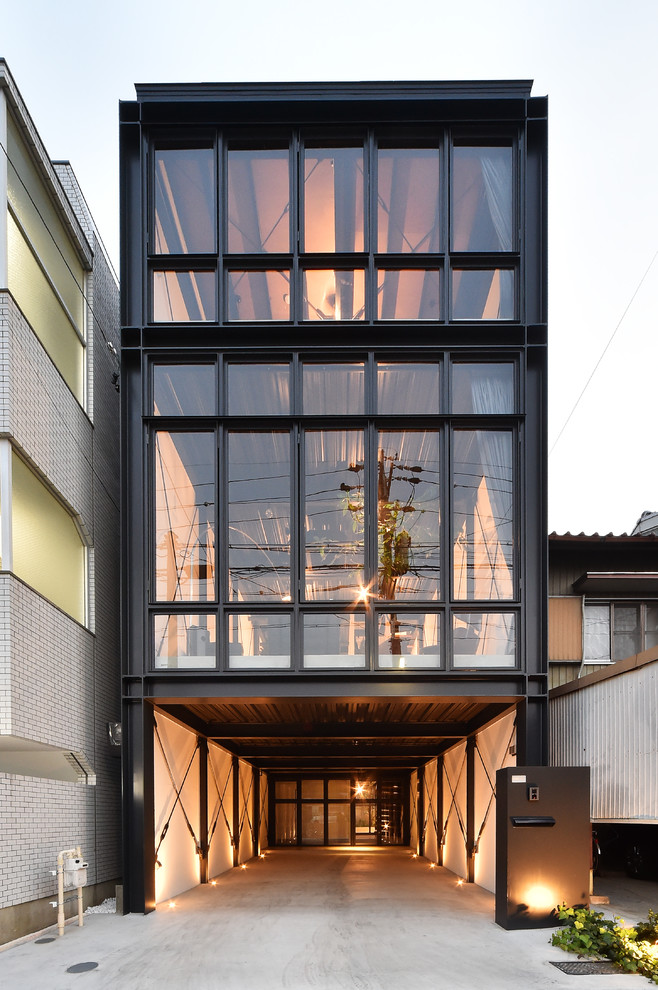 Dreistöckiges Industrial Haus mit schwarzer Fassadenfarbe und Flachdach in Nagoya