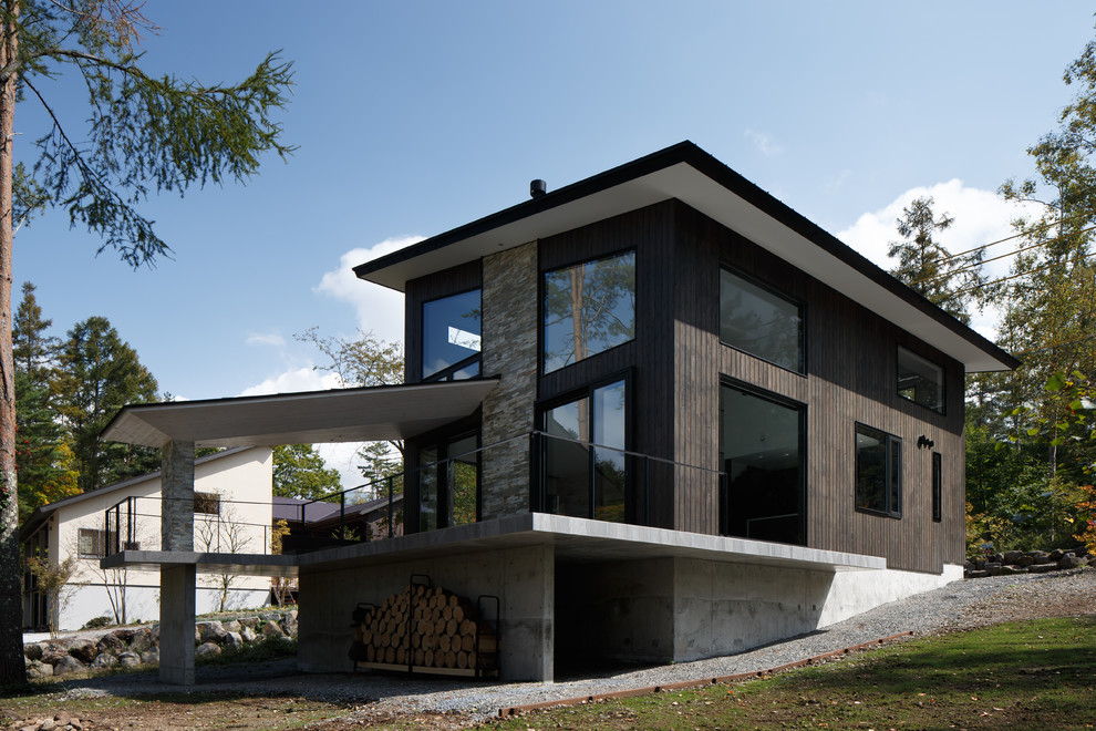 Diseño de fachada gris contemporánea con revestimiento de madera y tejado de un solo tendido
