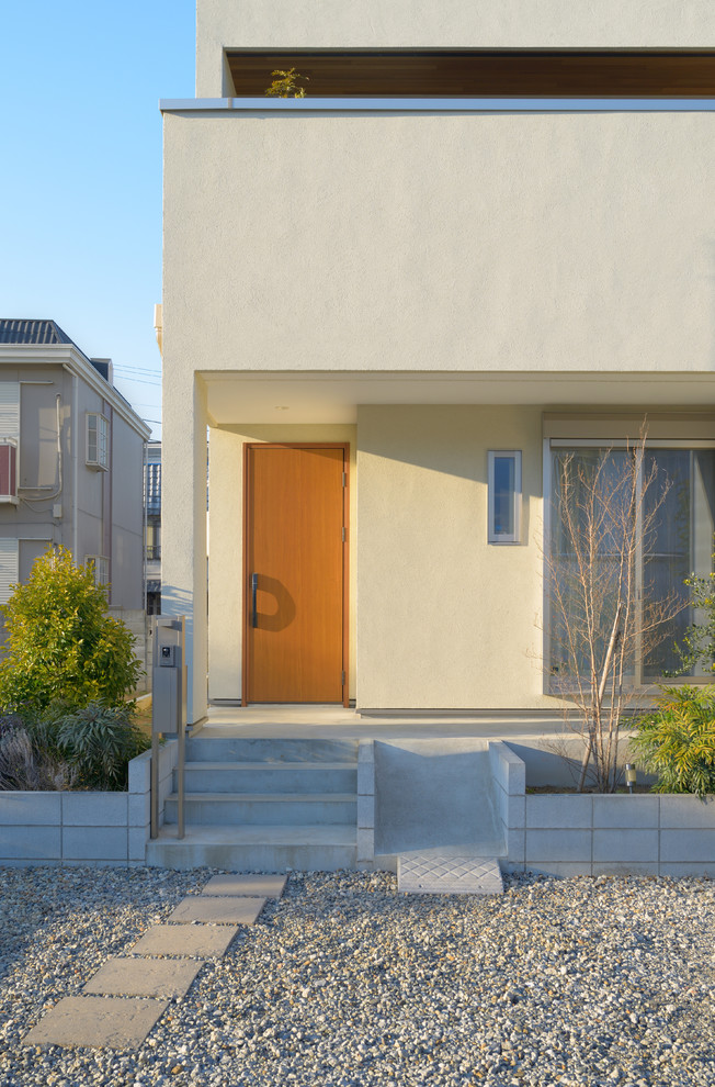 Réalisation d'une façade de maison beige minimaliste de taille moyenne.