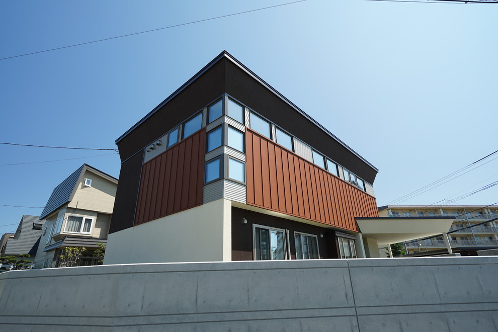 Idées déco pour une petite façade de maison métallique et marron à un étage avec un toit plat et un toit en métal.