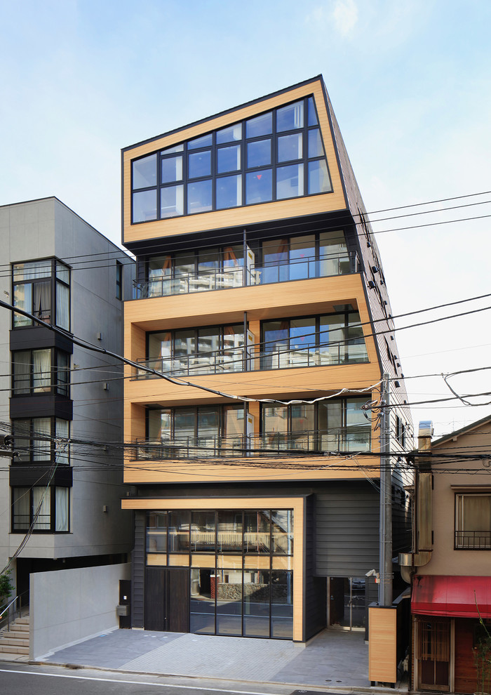 Стильный дизайн: огромный, трехэтажный, черный многоквартирный дом в стиле модернизм с облицовкой из металла, односкатной крышей и металлической крышей - последний тренд