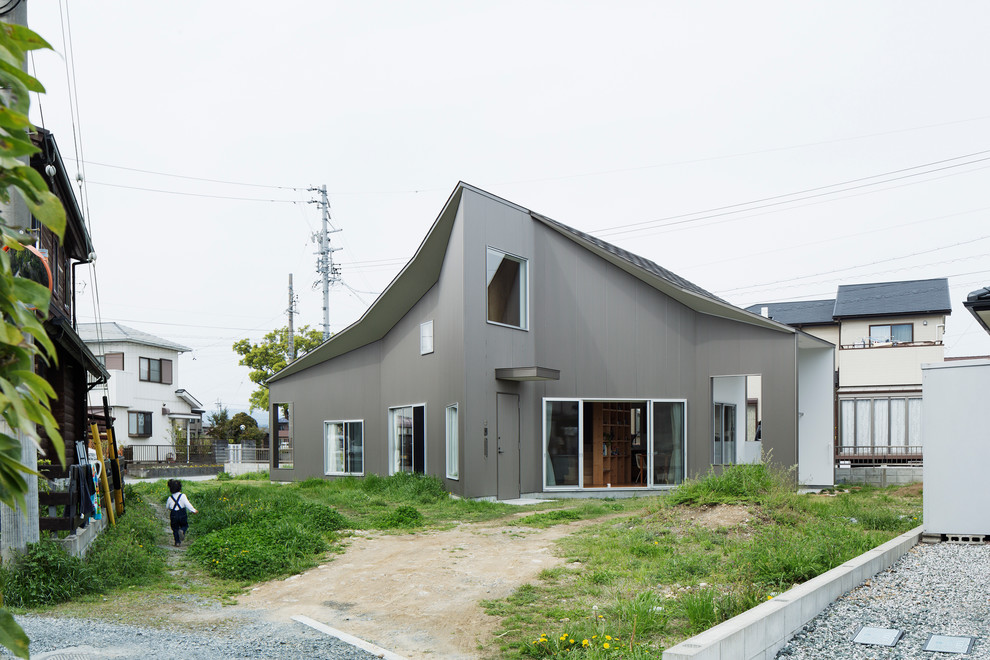 Foto de fachada gris contemporánea con tejado a dos aguas