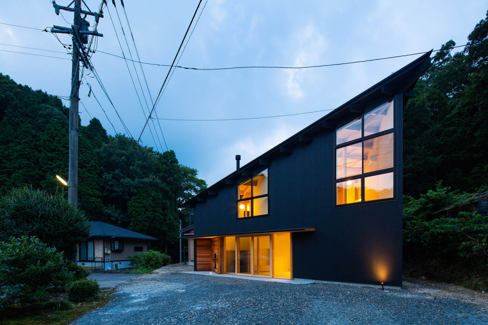 Imagen de fachada de casa negra de estilo zen pequeña de dos plantas con revestimiento de madera, tejado de un solo tendido y tejado de metal