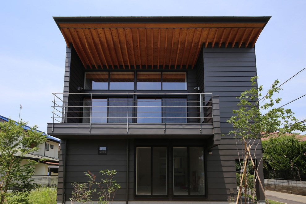 Свежая идея для дизайна: маленький, двухэтажный, серый частный загородный дом в восточном стиле с односкатной крышей и металлической крышей для на участке и в саду - отличное фото интерьера