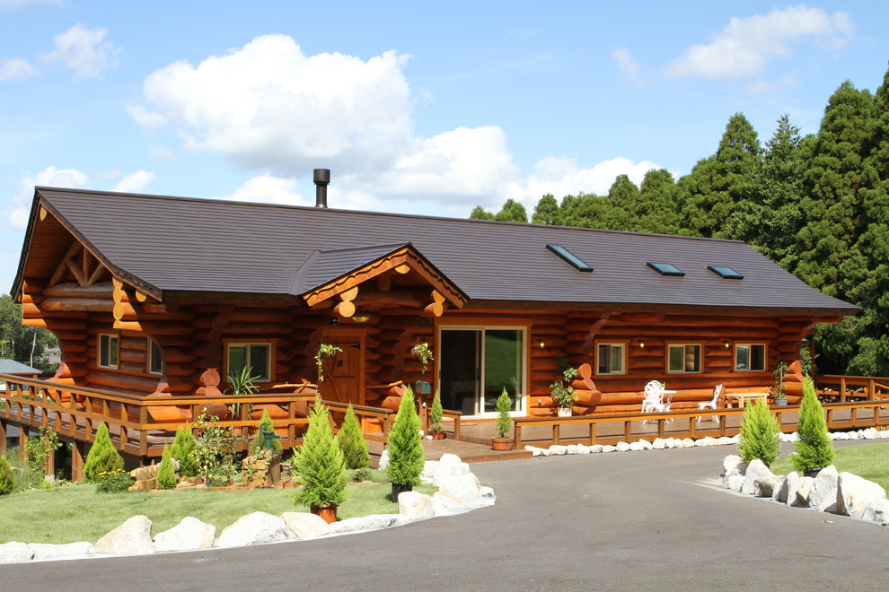 Cette photo montre une façade de maison marron montagne avec un toit à deux pans et un toit noir.
