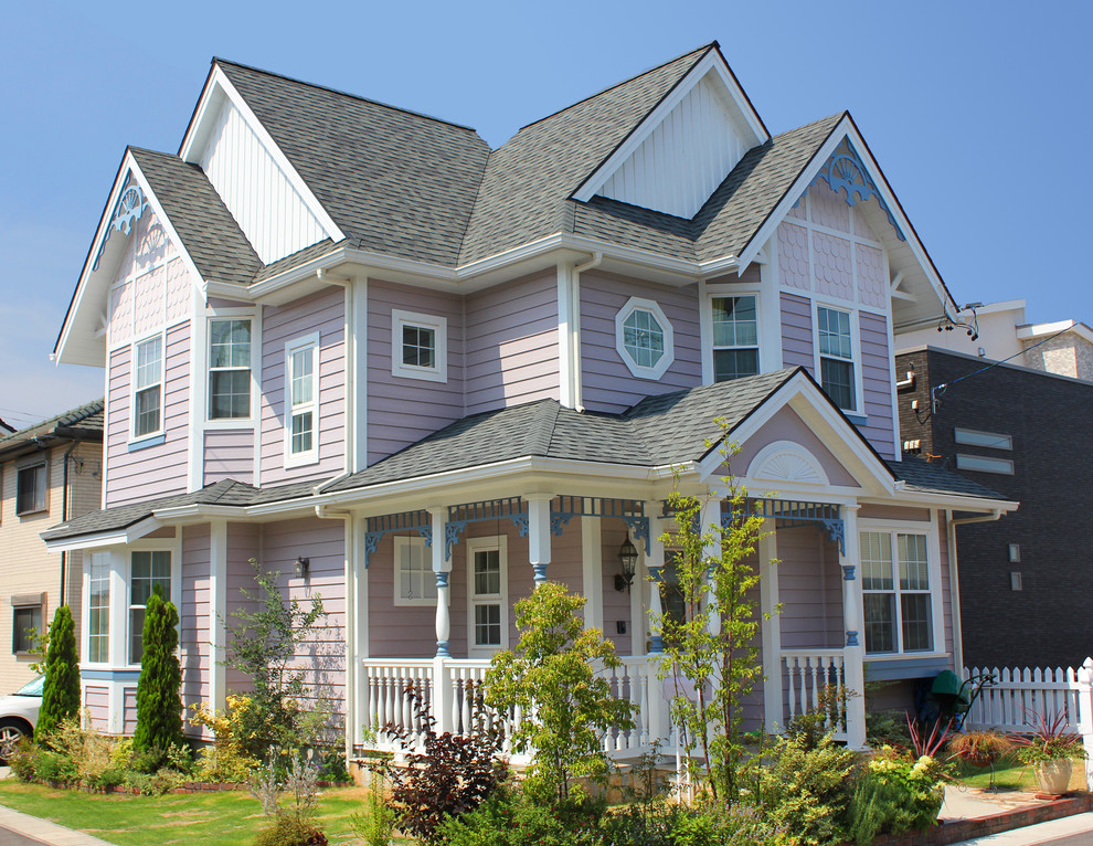 Foto della facciata di una casa rosa vittoriana a due piani con rivestimenti misti e tetto a capanna