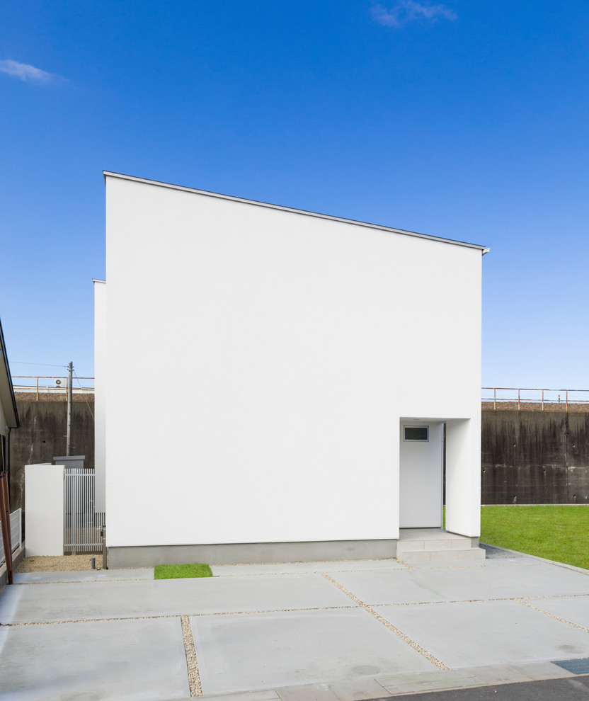 Idée de décoration pour une façade de maison blanche minimaliste à un étage avec un toit en appentis.
