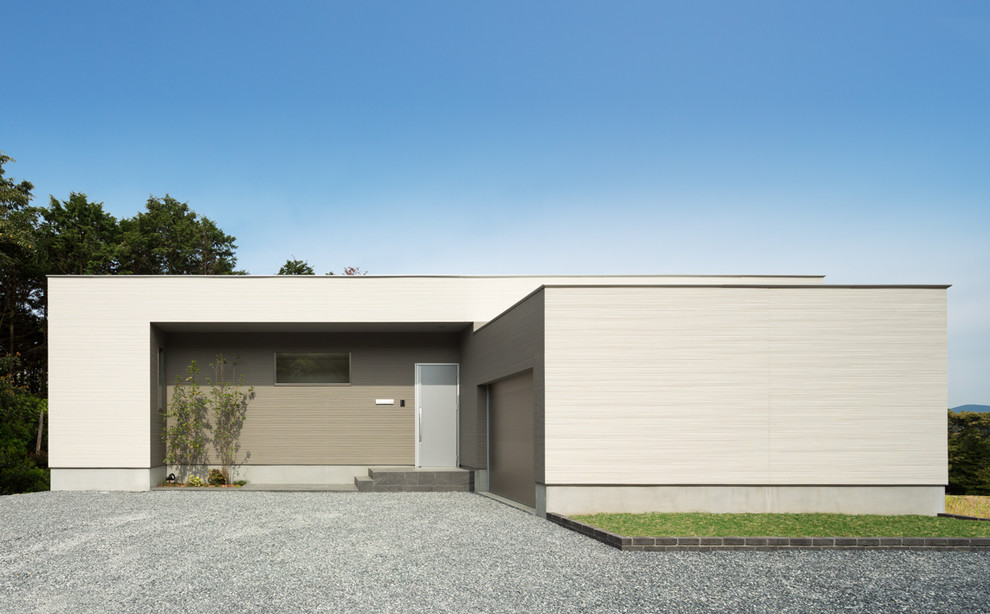 Réalisation d'une façade de maison grise minimaliste de plain-pied avec un toit plat et un revêtement mixte.