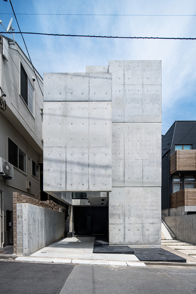 Mittelgroßes Industrial Haus mit Betonfassade und grauer Fassadenfarbe in Tokio