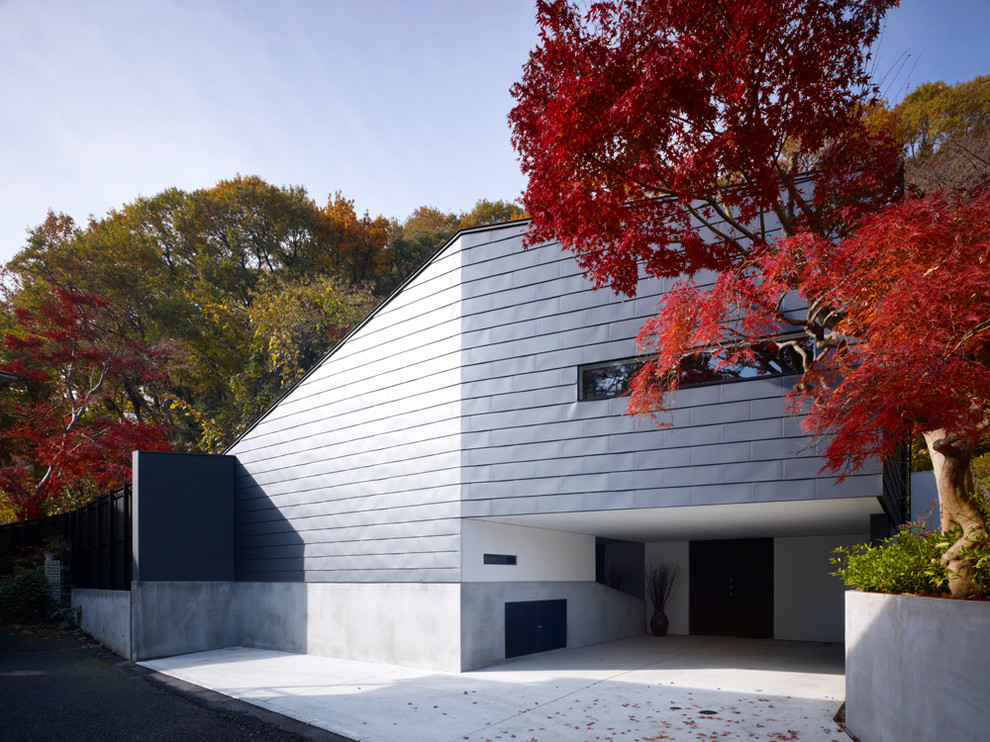 Diseño de fachada de casa gris y gris moderna de tamaño medio de dos plantas con revestimientos combinados y tejado de metal