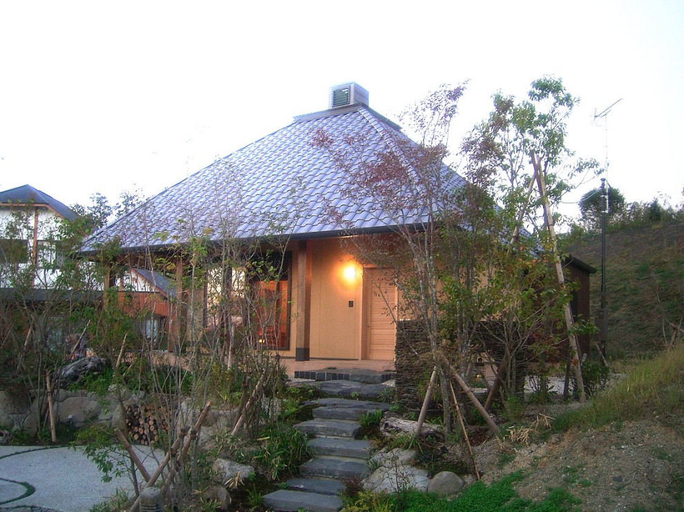 Imagen de fachada de casa beige clásica de tamaño medio de dos plantas con revestimiento de estuco, tejado a cuatro aguas y tejado de teja de barro