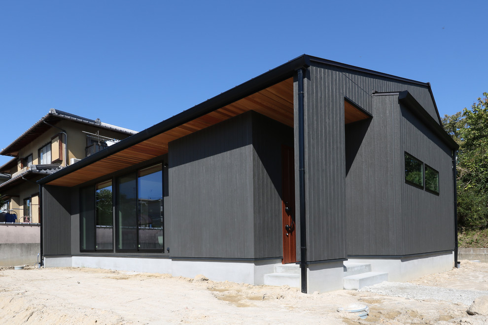 Inspiration for a modern black one-story mixed siding exterior home remodel in Other with a metal roof