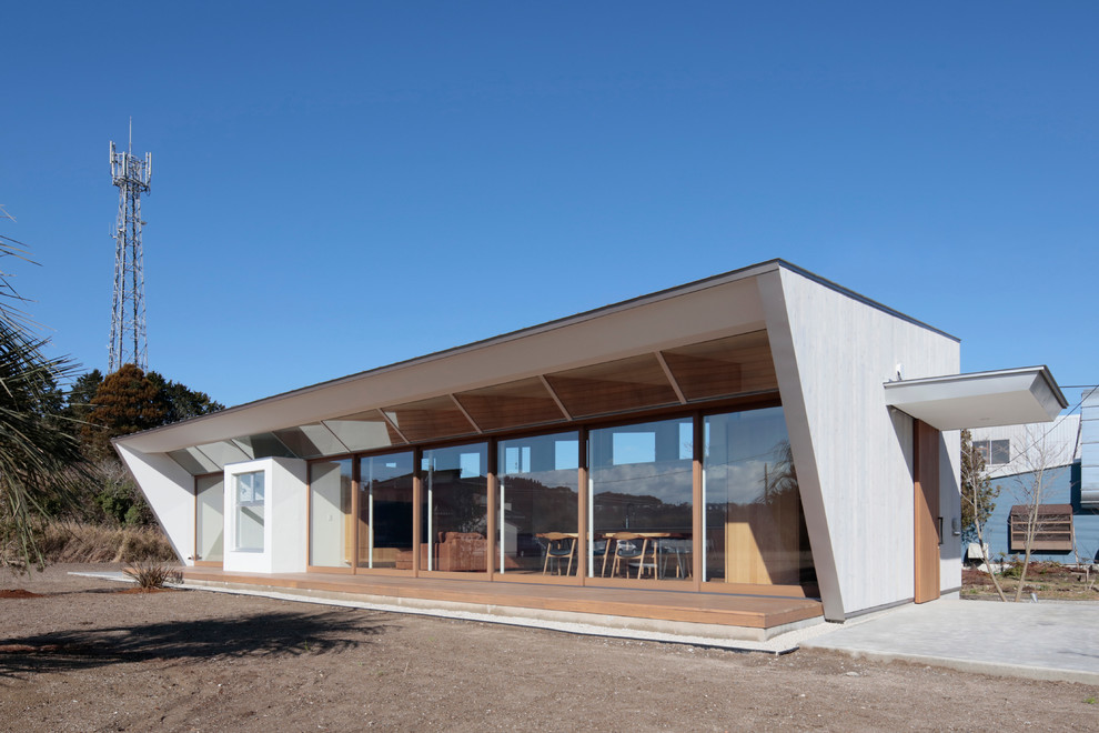 Idées déco pour une façade de maison blanche moderne en bois de plain-pied avec un toit en appentis.