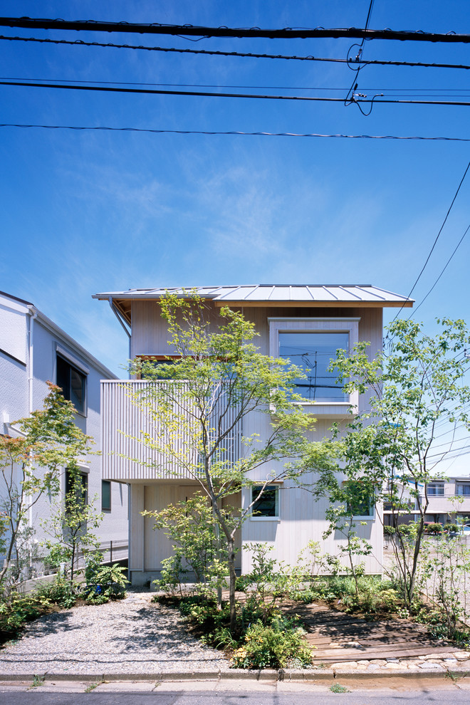 White world-inspired detached house in Tokyo Suburbs with wood cladding, a pitched roof and a metal roof.
