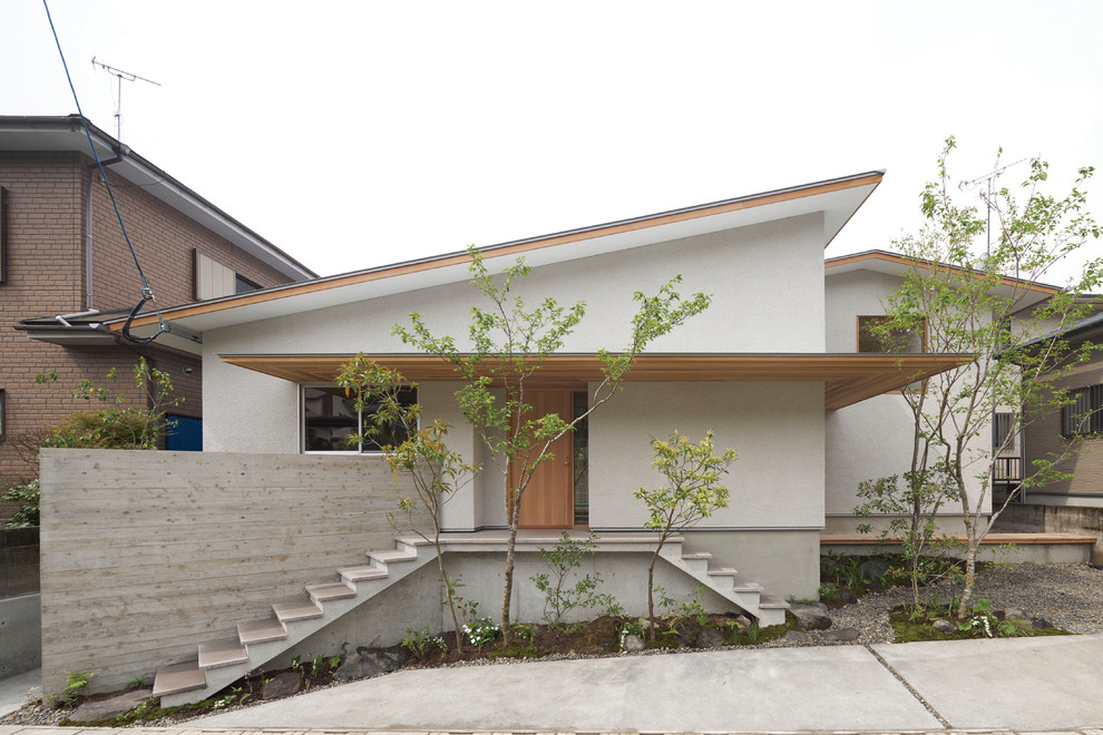 Einstöckiges Asiatisches Haus mit weißer Fassadenfarbe und Pultdach in Sonstige