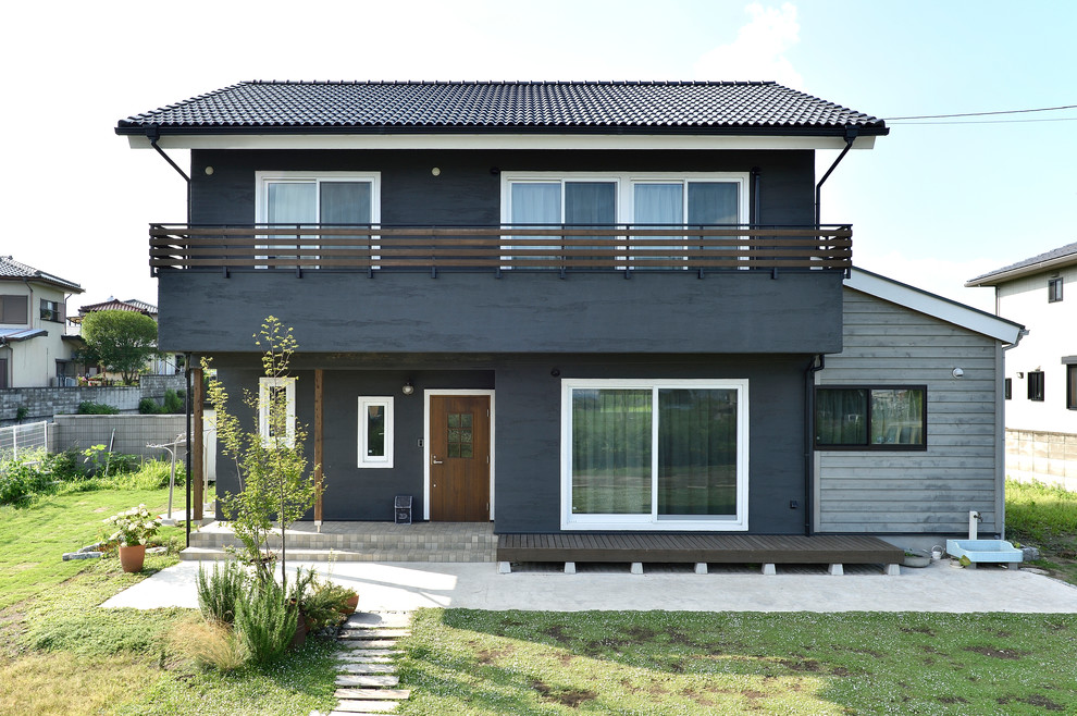 Diseño de fachada de casa negra asiática de dos plantas con tejado a dos aguas y tejado de teja de barro