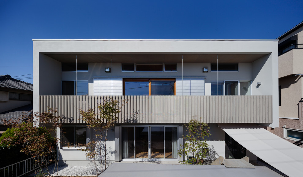 Modelo de fachada de casa gris actual de tamaño medio de dos plantas con tejado plano