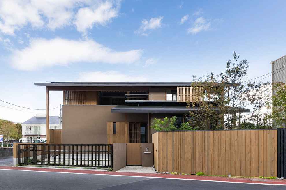 Zweistöckiges Asiatisches Einfamilienhaus mit beiger Fassadenfarbe, Satteldach und Blechdach in Sonstige