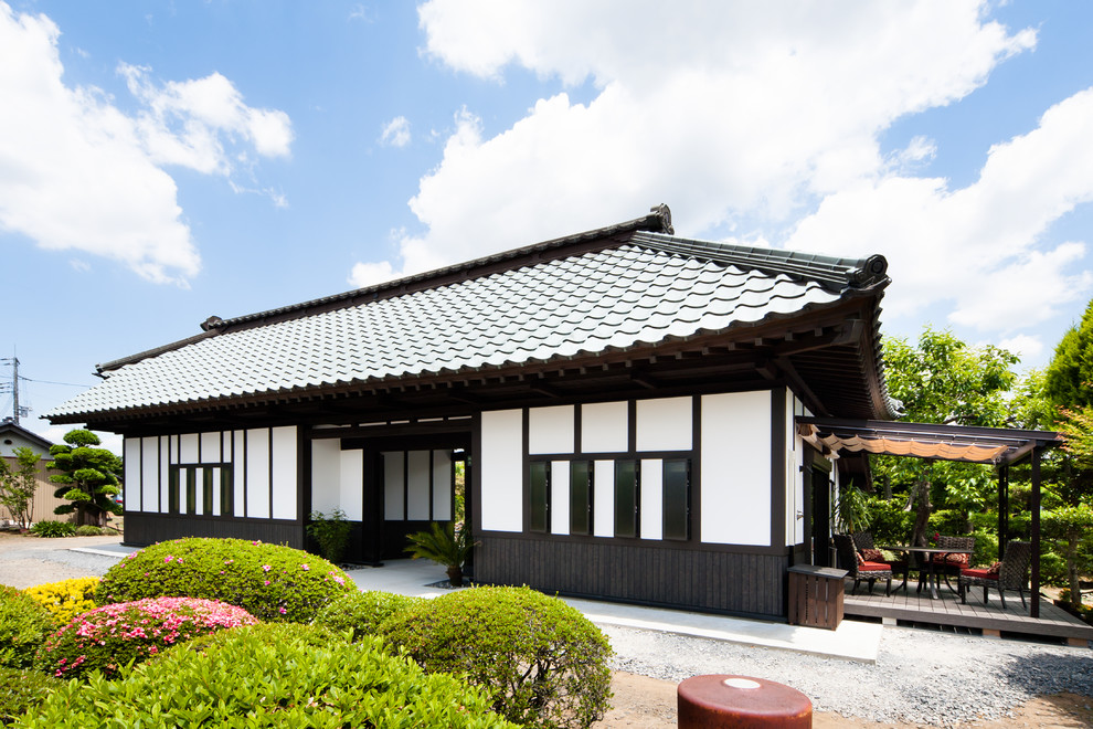 Kleines, Einstöckiges Asiatisches Einfamilienhaus mit weißer Fassadenfarbe, Walmdach und Ziegeldach in Sonstige