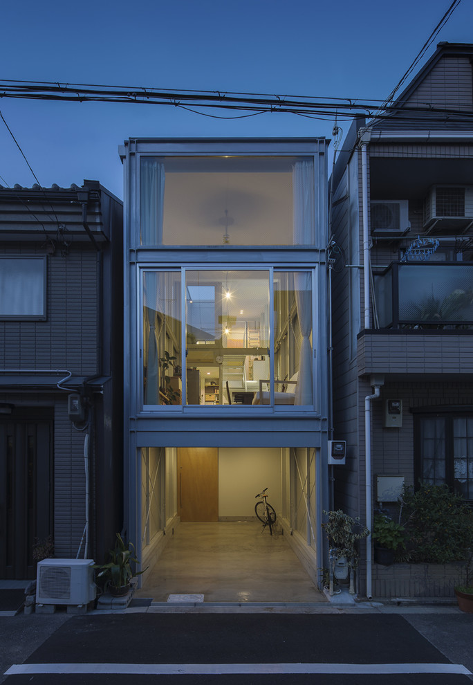 Kleines Modernes Einfamilienhaus mit Metallfassade, grauer Fassadenfarbe, Pultdach und Blechdach in Osaka