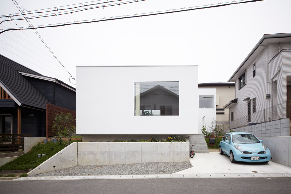 Einstöckiges, Kleines Modernes Haus mit Putzfassade, weißer Fassadenfarbe und Flachdach in Sonstige