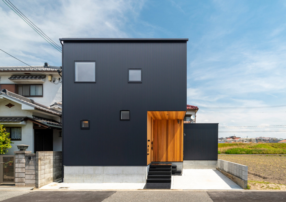 Example of a mid-sized minimalist black two-story metal exterior home design in Kobe with a metal roof