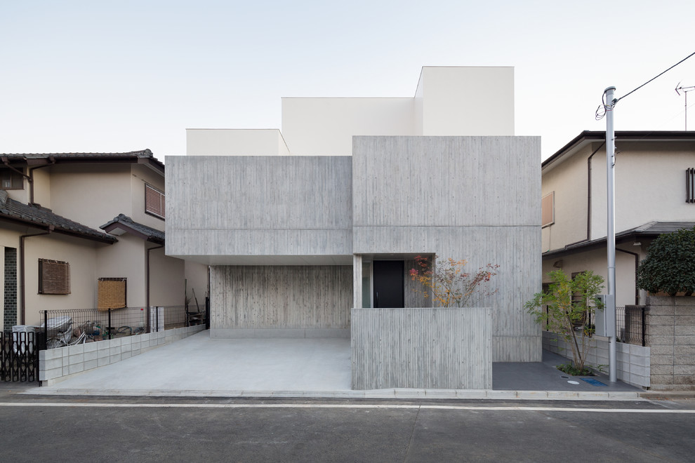На фото: двухэтажный, серый частный загородный дом в стиле модернизм с облицовкой из бетона и плоской крышей с