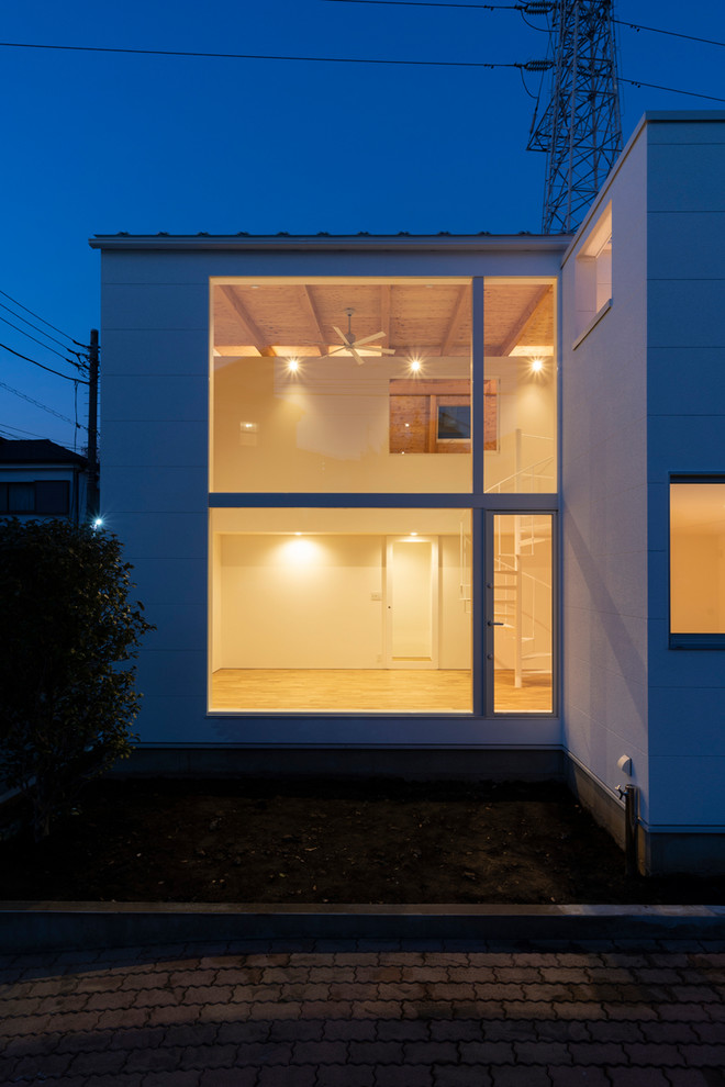 Modelo de fachada de casa blanca moderna pequeña de dos plantas con revestimientos combinados, tejado a dos aguas y tejado de metal