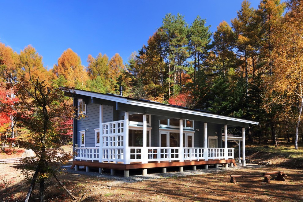 Пример оригинального дизайна: деревянный, синий дом из бревен в скандинавском стиле с односкатной крышей