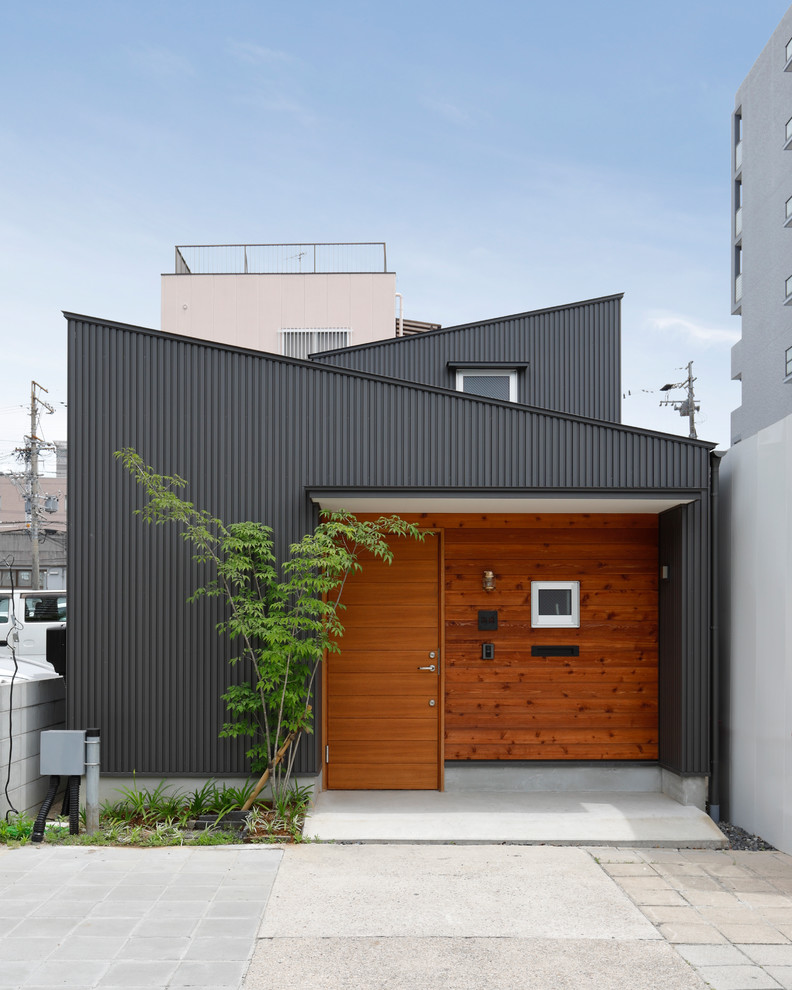 Inspiration pour une façade de maison noire chalet de plain-pied avec un toit en appentis et un toit en métal.