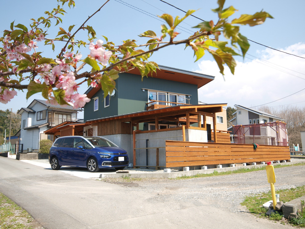 На фото: двухэтажный, зеленый частный загородный дом в морском стиле с односкатной крышей и металлической крышей с