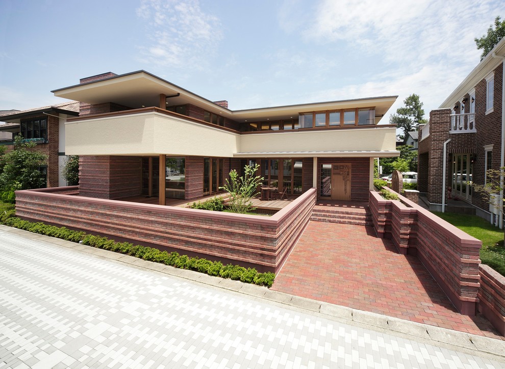 Aménagement d'une façade de maison marron en brique à un étage avec un toit plat.