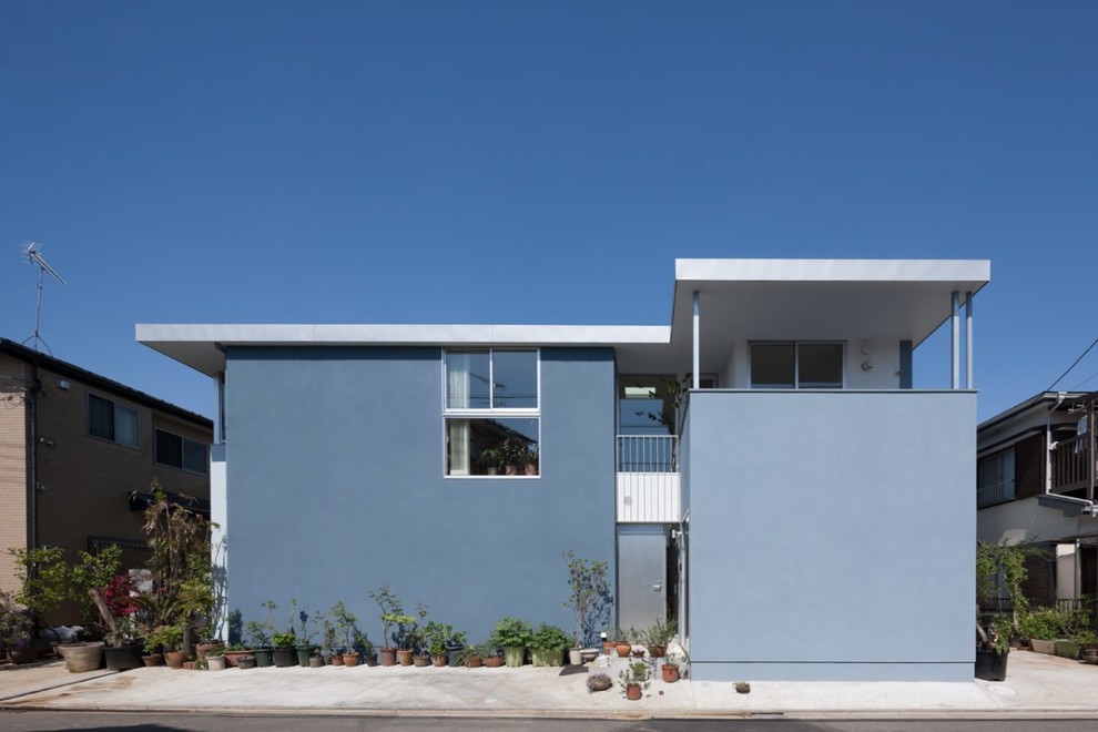 Idées déco pour une façade de maison bleue contemporaine avec un toit plat.