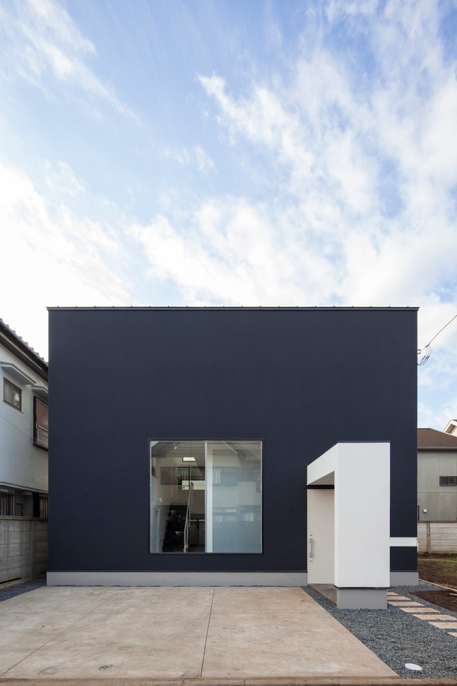 Imagen de fachada de casa negra minimalista de dos plantas con tejado plano y tejado de metal