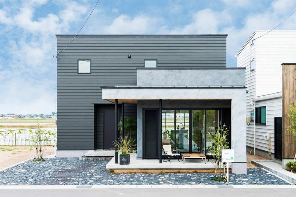Idées déco pour une façade de maison noire industrielle de taille moyenne et à un étage avec un revêtement mixte, un toit en appentis et un toit en métal.