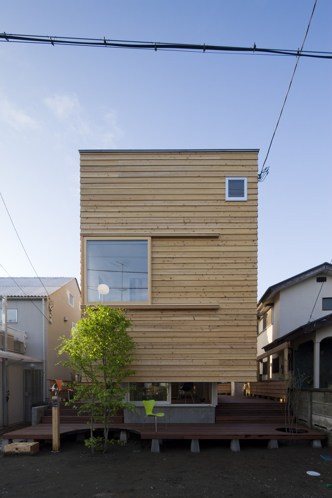 Réalisation d'une façade de maison marron design en bois avec un toit plat.