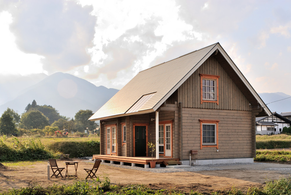 На фото: деревянный, коричневый дом из бревен в стиле кантри с двускатной крышей