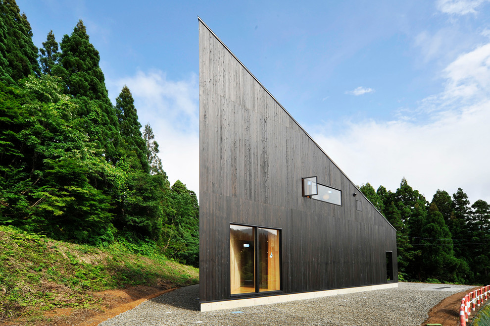 Imagen de fachada negra actual con revestimiento de madera y tejado de un solo tendido