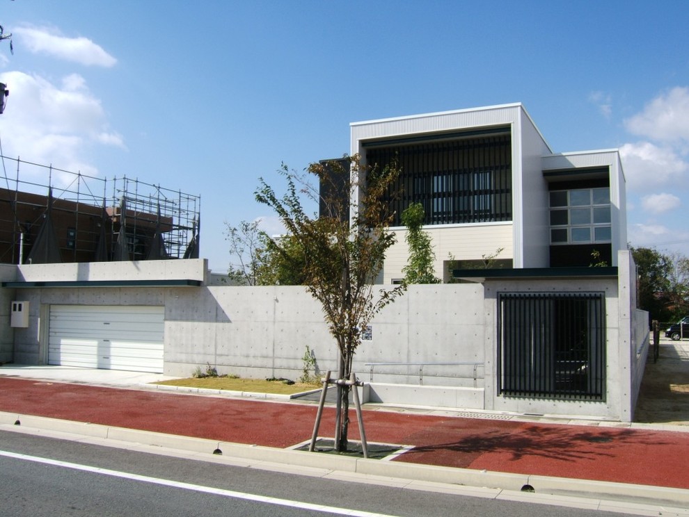 Idées déco pour une façade de maison grise moderne avec un revêtement mixte et un toit plat.