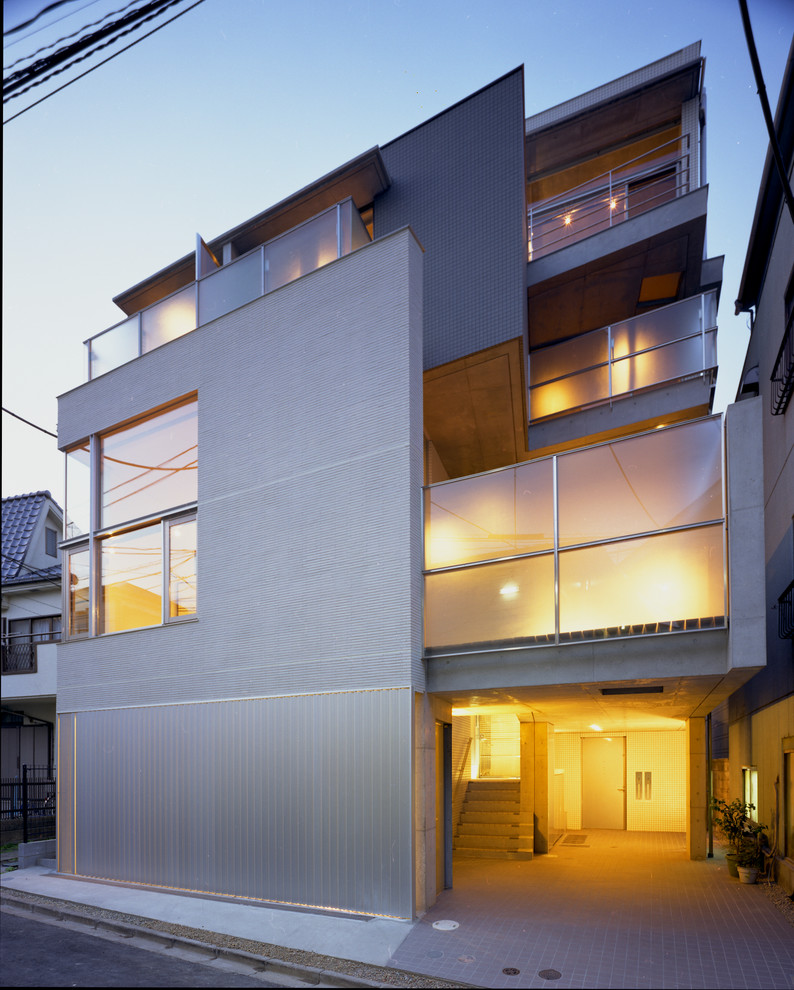 Große, Dreistöckige Moderne Doppelhaushälfte mit Betonfassade, grauer Fassadenfarbe und Flachdach in Tokio