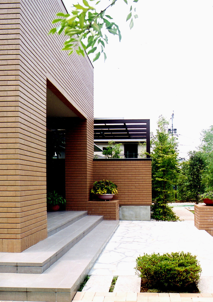 Immagine della villa grande marrone contemporanea a due piani con tetto a padiglione