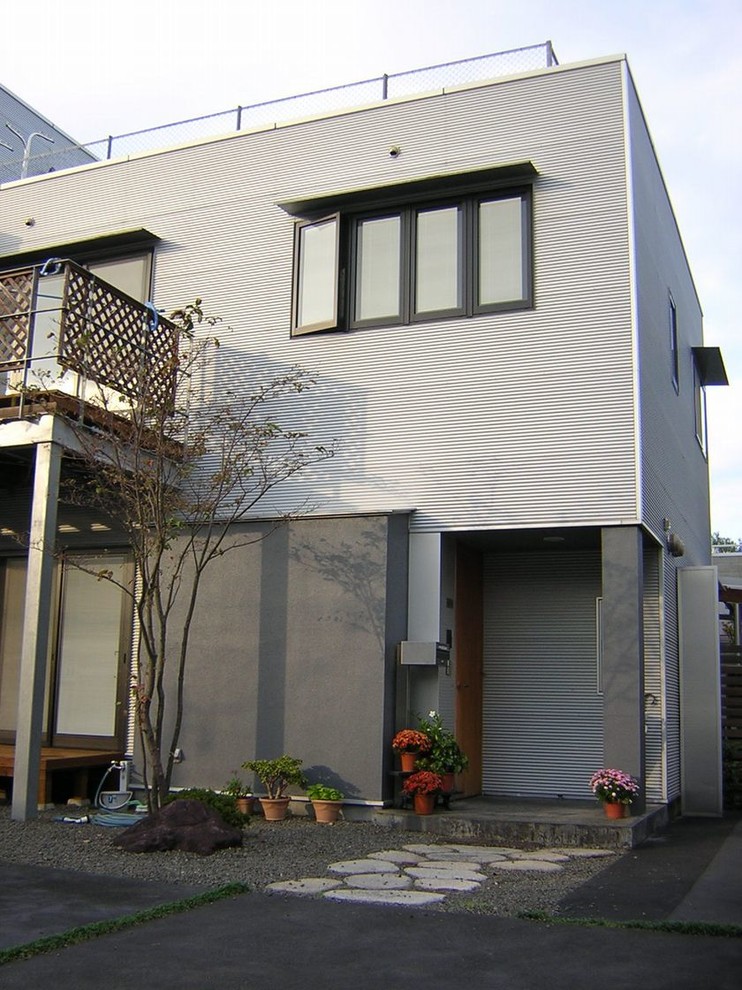 Réalisation d'une façade de maison métallique urbaine de taille moyenne et à un étage avec un toit plat.
